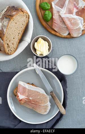 Parmaschinken auf rustikalen Sauerteigbrot mit Butter und Milch Stockfoto