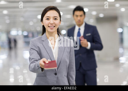 Junge Geschäftsfrau zeigt ihren Pass am Flughafen Stockfoto