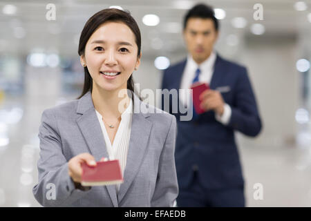 Junge Geschäftsfrau zeigt ihren Pass am Flughafen Stockfoto