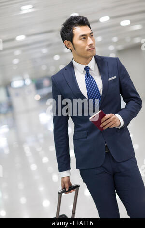 Junge Unternehmer Wandern im Flughafen mit Koffer Stockfoto