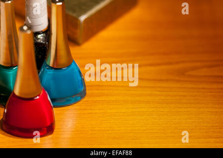 Drei Flaschen mit Kosmetik auf Schreibtisch in einem Raum Stockfoto