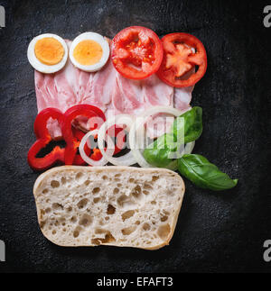 Zutaten für Sandwich mit Schinken, Eiern und Gemüse auf schwarzem Hintergrund. Ansicht von oben Stockfoto