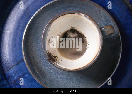 Blaue Keramik Tasse Kaffeesatz über blaue Keramik Tablett. Ansicht von oben. Stockfoto