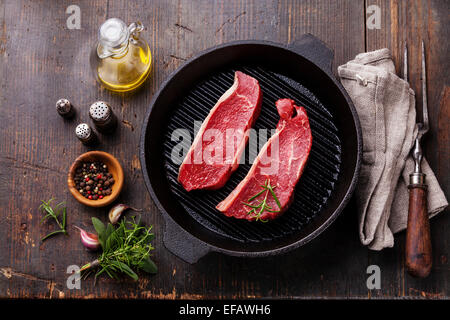 Seltene Striploin Steak Grillpfanne und Gewürze auf hölzernen Hintergrund Stockfoto