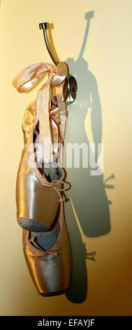 Hängende Ballett Schuhe Schattenwurf an der Wand. Stockfoto