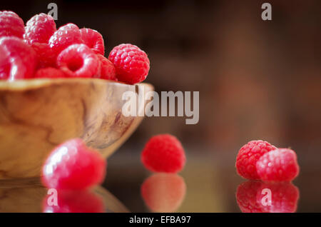 Frische Himbeeren, die aus einer Holzschale überlaufen Stockfoto