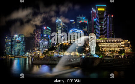 Merlion Statue und Wolkenkratzer in Singapur bei Nacht Stockfoto