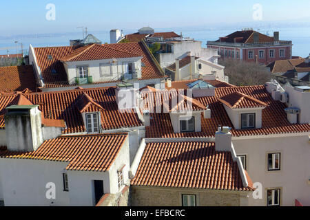 Ein Blick über den gefliesten Dächern Lissabons Altstadt auf den Tejo. Stockfoto