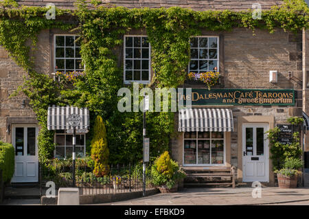 Die Außenseite des malerisch einladenden sonnigen Efeu bewachsenen Dalesman Café Teestube & Süße Emporium (Name über der Tür) - Gargrave, North Yorkshire, England, UK. Stockfoto