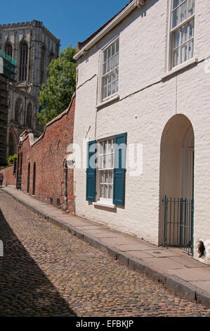 Unter blauem Himmel, bis auf Kopfsteinpflaster, historisches Kapitel House Street mit weiß getünchten Haus auf einem Turm von York Minster - North Yorkshire, England, UK. Stockfoto