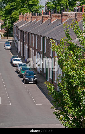 Blick über die Dächer der Reihe von malerischen attraktiven roten Backstein viktorianischen Reihenhäuser (Hütten) & Autos geparkt auf der Straße - Bishophill, York, England, Großbritannien. Stockfoto