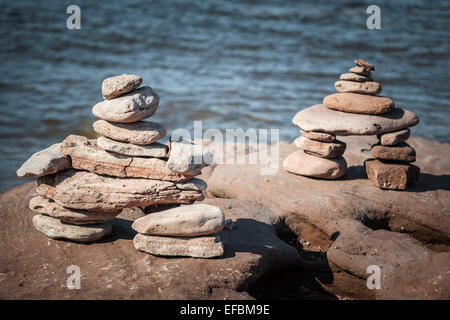 Zwei kleine gestapelte Inuksuk oder Cairns Stein Wahrzeichen von Atlantik Küste. Prince Edward Island, Kanada. Stockfoto