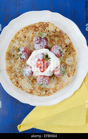 Laskiaispulla Pancake Pfannkuchen mit Erdbeeren und Sahne auf dunklen blau Vintage shabby schicke Tabelle, vertikale Dienstag. Stockfoto