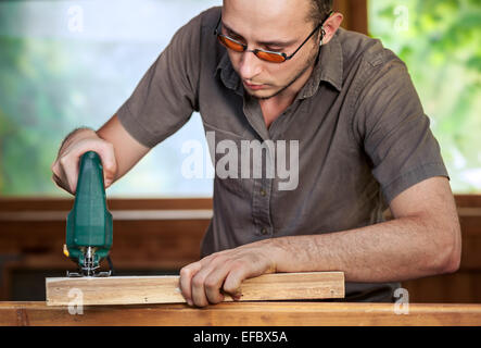 Junger Mann mit Holz zu arbeiten Stockfoto