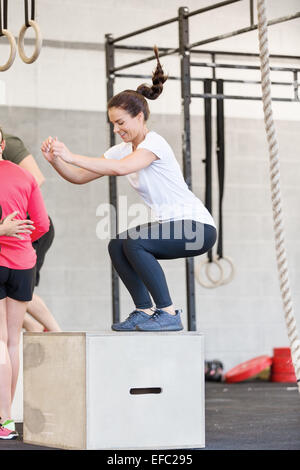 Junge Frau trainiert Crossfit Box jumps Stockfoto