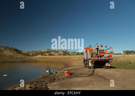 Ein Foto von dem Nachfüllen des Wassertanks ein Feuerwehrauto im Anschluss an ein Buschfeuer auf einer trockenen australischen Farm. Stockfoto