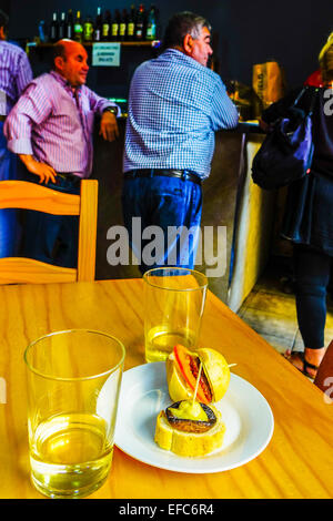 Tapas und zwei Gläser Weißwein auf Tisch in bar, Benidorm, Costa Blanca, Spanien Stockfoto