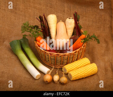 Eine Vielzahl von Garten wachsen Gemüse, einige in einem Weidenkorb auf hessischen Hintergrund Stockfoto