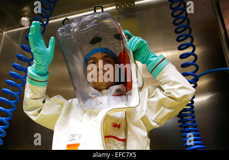 Wuhan, China Hubei Provinz. 30. Januar 2015. Ein Forscher setzt auf einen Schutzanzug vor dem Eintritt in die neu abgeschlossen-Lab in Wuhan, der Hauptstadt der Provinz Zentral-China-Hubei, 30. Januar 2015. China hat seine erste hohe Niveau Biosafety-Labor mit Sitz in Wuhan Samstag in Wuhan nach mehr als einem Jahrzehnt der Bau abgeschlossen Das Labor wird zur studieren Klasse vier Erreger (P4), bezieht sich auf die heftigsten Viren, die eine hohe Gefahr von Mensch zu Mensch Infektionen Aerosol übertragen. © Yin Gang/Xinhua/Alamy Live-Nachrichten Stockfoto