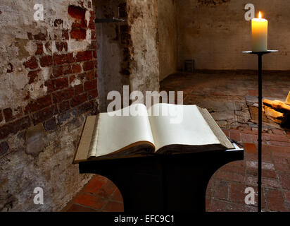 Offenes Buch mit leeren Seiten und Kerze Stockfoto