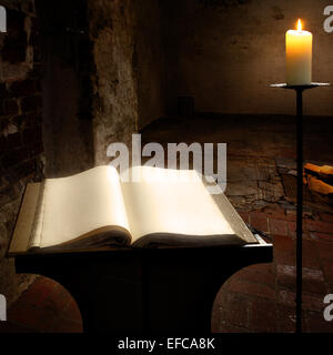 Offenes Buch mit leeren Seiten und Kerze Stockfoto