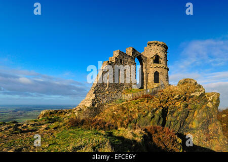 Mow Cop Burg, eine Torheit an der Grenze von Cheshire-Staffordshire; Landschaft im Hintergrund; blauer Himmel mit weißen Wolken. Stockfoto