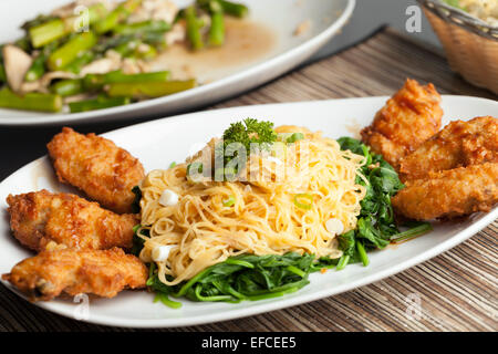 Chicken Wings mit Nudeln und Spinat Stockfoto