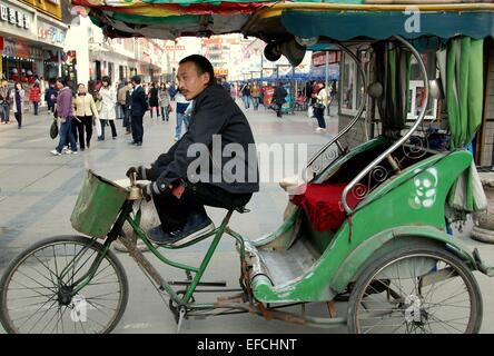 Chengdu, China: Rikscha-Fahrer sitzt in seinem Fahrrad Taxi wartet auf einen Tarif auf belebten Chun Xi Straße Stockfoto