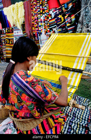 Eine Frau webt buntes Tuch mit traditionellen Mustern auf ihre hausgemachten Webstuhl im Freien in Antigua, Guatemala, Mittelamerika. Stockfoto