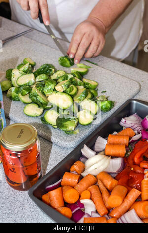 Miami Beach, Florida, Küche, weibliche Frauen, zubereiten, kochen, Gemüse, brisket, Fleisch, Abendessen, Rosenkohl, Karotten, FL141225007 Stockfoto