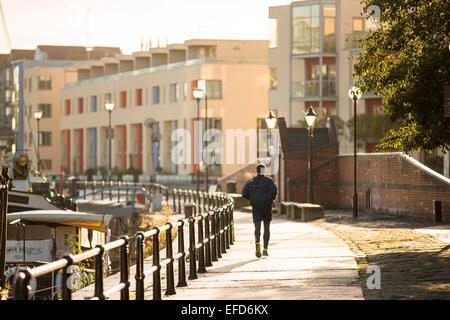 Mann, Joggen in der frühen Morgensonne entlang der Hafenpromenade in Bristol, England. Stockfoto