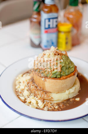 Pieminister Kuchen serviert mit Kartoffelpüree, Erbsenpüree, Zwiebeln und Käse in St Nicks Markt, Bristol. Stockfoto