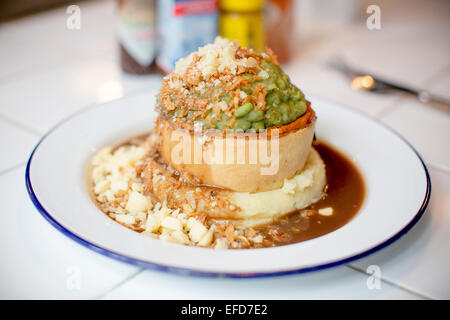 Pieminister Kuchen serviert mit Kartoffelpüree, Erbsenpüree, Zwiebeln und Käse in St Nicks Markt, Bristol. Stockfoto