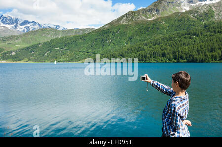 Junge am Ufer eines Bergsees Stockfoto