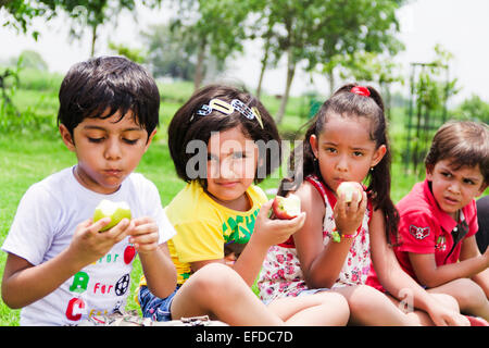 4 indische Kinder Freunden Picknick Park Essen Apfel Stockfoto