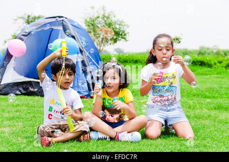 3 indische Kinder Freunden Picknick Parken spielen Bubble-Zauberstab Stockfoto