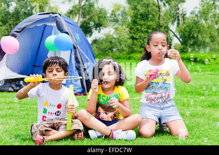 3 indische Kinder Freunden Picknick Parken spielen Bubble-Zauberstab Stockfoto