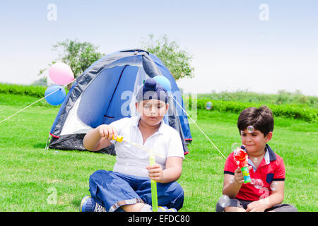 2 indische Kinder Freund Picknick Park spielen Bubble-Zauberstab Stockfoto