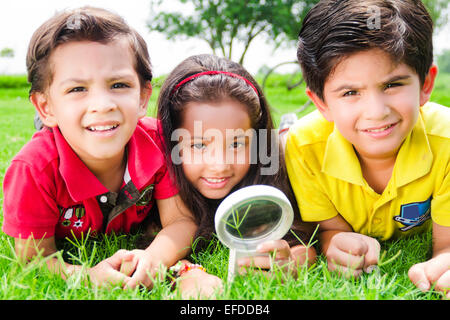 3 indische Kinder Freunde Parken Lupe suchen Stockfoto