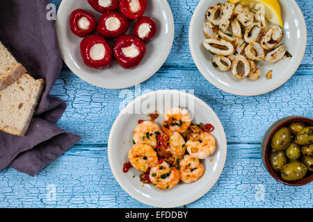Tapas von Tintenfisch, gefüllte Paprika, Oliven und Garnelen Stockfoto