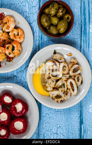 Tapas von Tintenfisch, gefüllte Paprika, Oliven und Garnelen Stockfoto