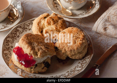 Ein Tisch für traditionelle englische Creme Tee. Marmelade und Gebäck mit einer Tischdecke und feines Porzellan mit Tageslicht Stockfoto