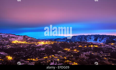 Schöne Berge Landschaft, erstaunlich, rosa und blauen Himmel über bergige leuchtende Stadt, Schönheit des nächtlichen, Winterurlaub Stockfoto