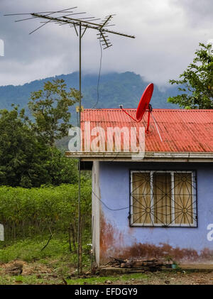 Telekommunikation-Prioritäten der großen Antenne und Satellitenschüssel auf dem Dach eines kleinen Hauses in Costa Rica Stockfoto