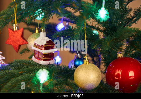 Weihnachtsschmuck und Farbe leuchtet über künstliche Tanne Stockfoto