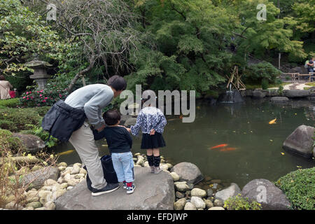 Mann mit seinen Kindern die Koi Fische, Hase-Dera Tempel, Kamakura, Japan Stockfoto