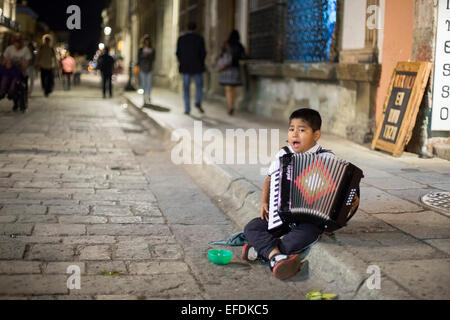 Oaxaca, Mexiko - ein sieben-Jahr-alter Junge spielt Akkordeon und singt für Tipps auf der Straße. Stockfoto