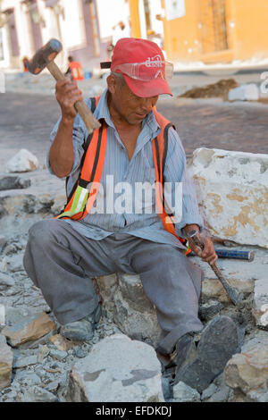 Oaxaca, Mexiko - Arbeitnehmer Gebrauch Hammer und Meißel, eine Straße mit Kopfsteinpflaster wieder aufzubauen. Stockfoto