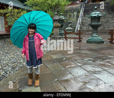 Mädchen mit einem leuchtend blauen Schirm, Kunozan Tosho-Go-Shinto-Schrein, Shizuoka, Japan Stockfoto