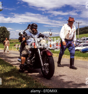 Ein älterer Mann in Volkskleidung, der Motorradfans vorbeizieht, Mähren, Tschechien Stockfoto